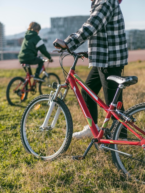 Photo gratuite deux garçons sur l'herbe avec leurs vélos