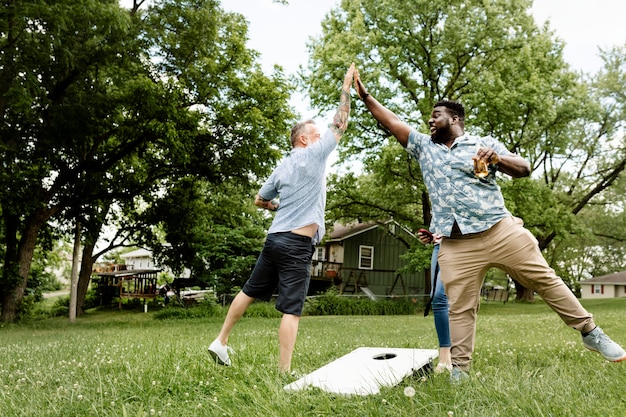 Photo gratuite deux gars se donnant un high five lors d'une fête d'été