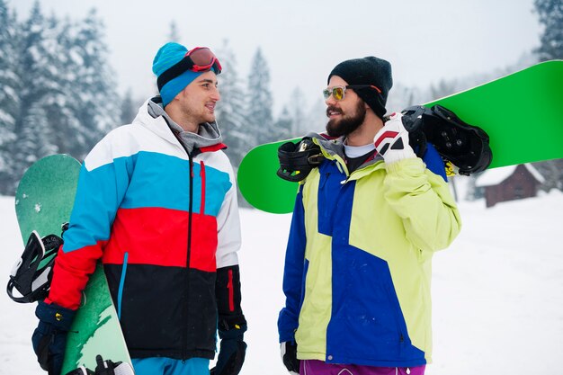 Deux gars avec des snowboards pendant les vacances d'hiver