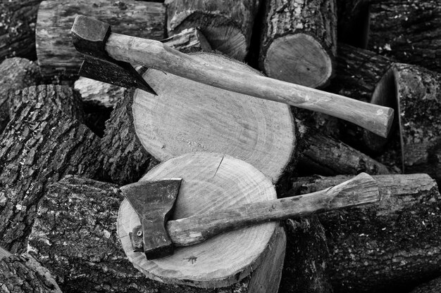 Deux haches en arrière-plan de souches de bois de chauffage haché photo noir et blanc