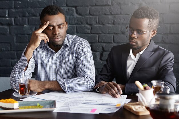 Deux hommes d'affaires afro-américains signant un contrat lors d'une réunion d'affaires au bureau