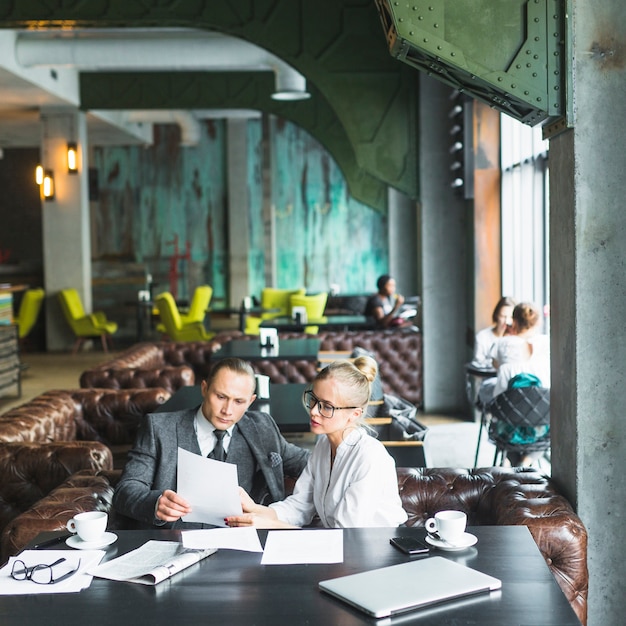 Deux hommes d'affaires regardant un document dans un café