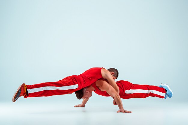 Deux hommes caucasiens acrobatiques de gymnastique en équilibre posent