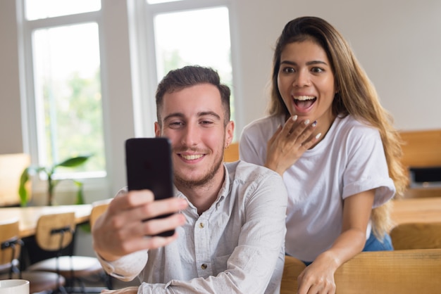 Deux hommes et femmes étudiantes heureux vidéoconférence au café