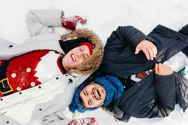 Deux hommes heureux couché sur la neige