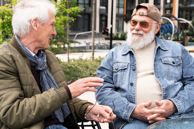 Photo gratuite deux hommes plus âgés dans la ville discutant ensemble