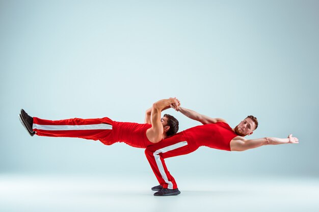 Les deux hommes de race blanche acrobatiques gymnastique sur l'équilibre posent