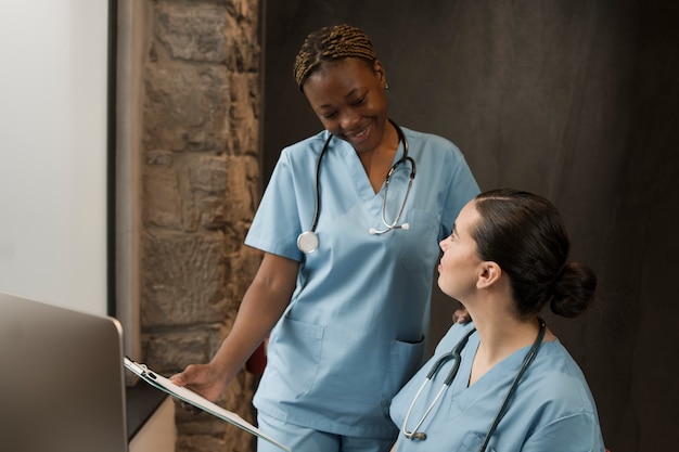 Photo gratuite deux infirmières travaillant à la clinique en gommage