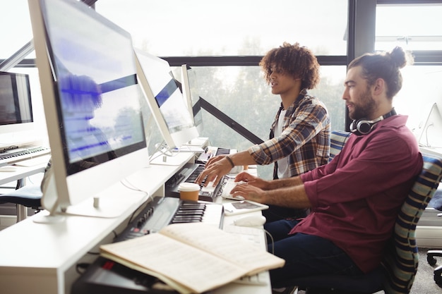 Photo gratuite deux ingénieurs du son travaillant ensemble