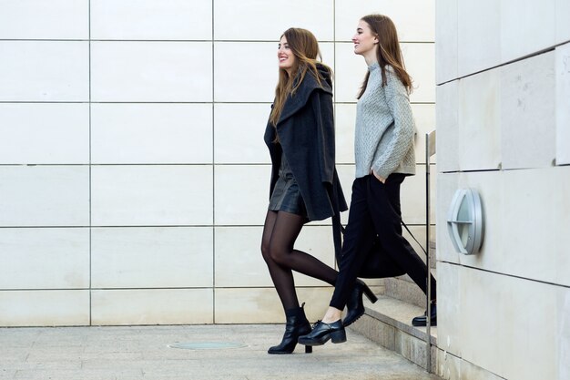 Deux jeune femme d&#39;affaires marchant dans la rue près du bureau de bureau