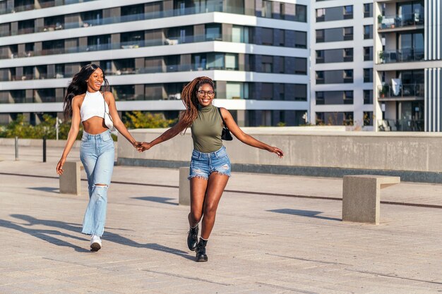 Deux jeunes amis noirs s'amusent à se promener dans la ville, concept d'amitié et de style de vie urbain, copiez l'espace pour le texte