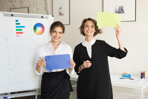 Deux jeunes belles femmes heureusement regardant à huis clos avec blanc b