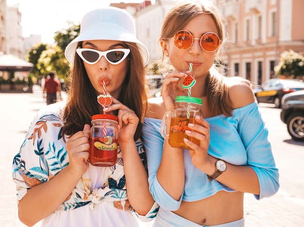 Photo gratuite deux jeunes belles filles hipster souriantes dans des vêtements d'été à la mode et un chapeau panama.