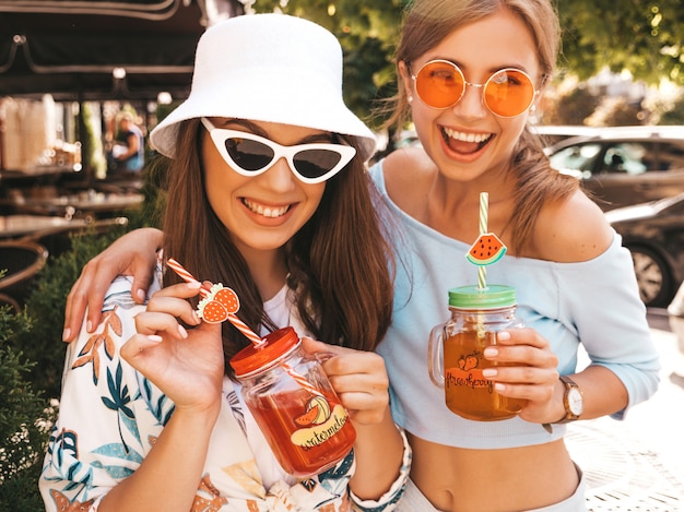 Deux jeunes belles filles hipster souriantes dans des vêtements d'été à la mode et un chapeau panama.