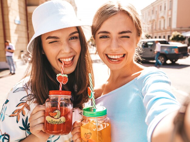 Deux jeunes belles filles hipster souriantes dans des vêtements d'été à la mode