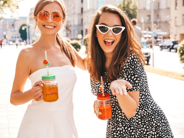 Deux jeunes belles filles hipster souriantes dans des vêtements d'été à la mode