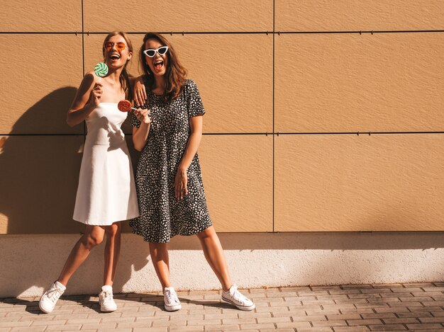 Deux jeunes belles filles hipster souriantes en robe d'été à la mode.