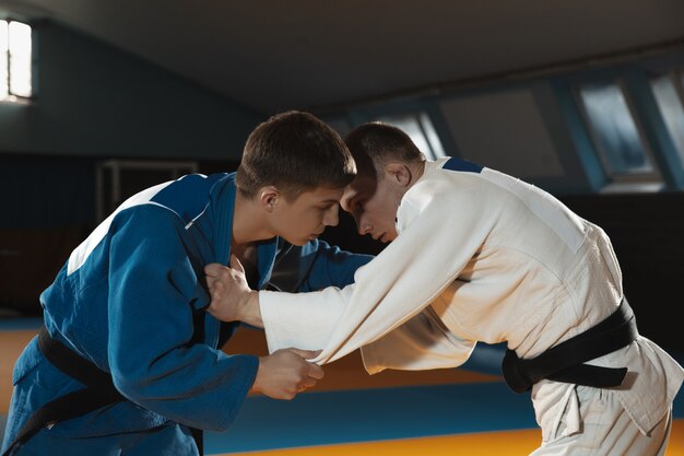 Deux jeunes combattants en kimono entraînant les arts martiaux dans le gymnase