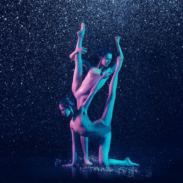 Deux jeunes danseuses de ballet sous des gouttes d'eau