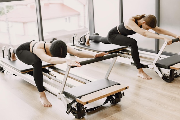 Photo gratuite deux jeunes femmes en forme s'entraînant dans une salle de sport