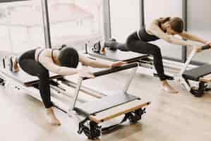 Photo gratuite deux jeunes femmes en forme s'entraînant dans une salle de sport