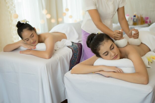 Deux jeunes femmes mignonnes aiment se détendre pendant le massage au spa.