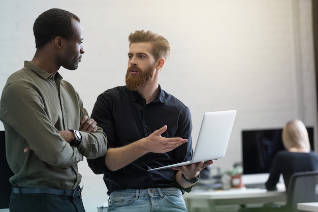 Deux jeunes hommes d'affaires intelligents discutant d'un nouveau projet