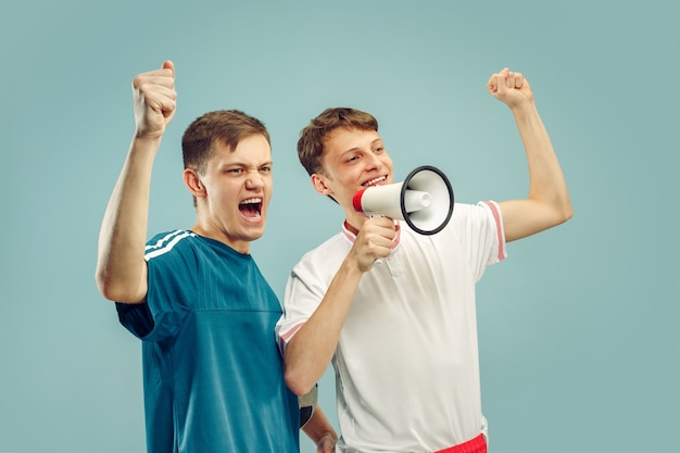 Deux jeunes hommes debout dans des vêtements de sport isolés sur bleu