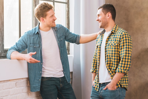 Deux jeunes hommes souriants qui se parlent