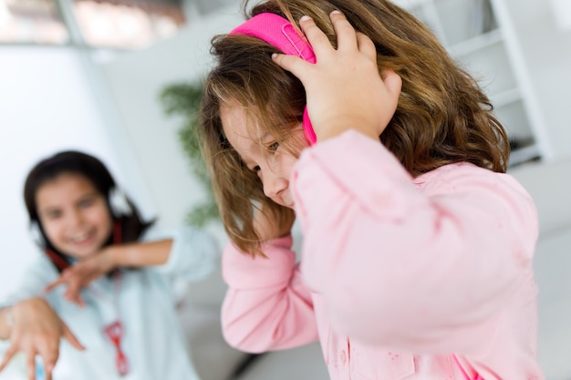 Deux jeunes soeurs écoutent de la musique et de la danse à la maison.