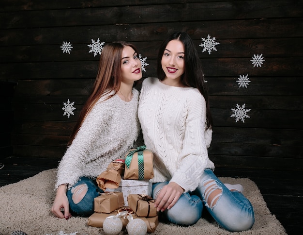 Deux jolies femmes posant avec des cadeaux pour Noël, vue rapprochée