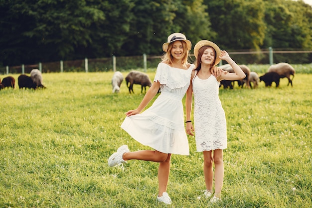 Deux jolies filles dans un champ avec une chèvre