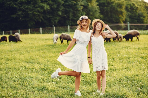 Deux jolies filles dans un champ avec une chèvre