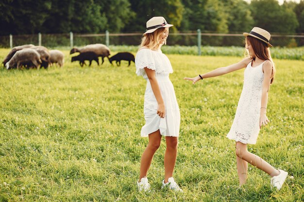 Deux jolies filles dans un champ avec une chèvre