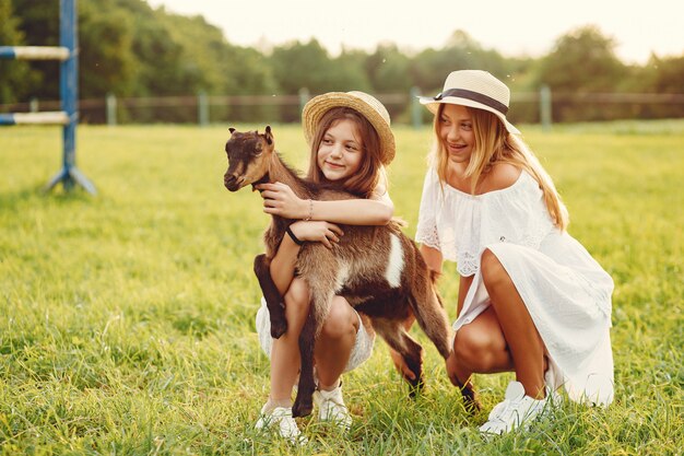 Deux jolies filles dans un champ avec une chèvre