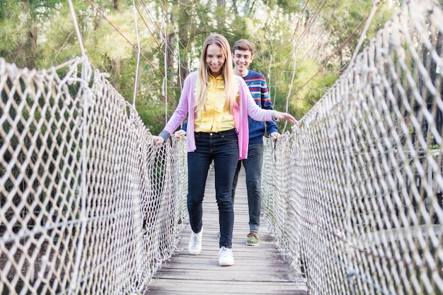 Photo gratuite deux joyful traversant un pont en bois