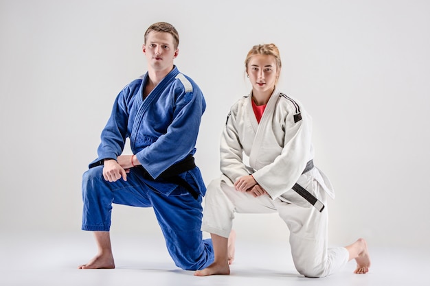 Photo gratuite les deux judokas combattants posant sur gris