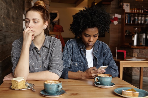 Photo gratuite deux lesbiennes malheureuses ne se parlant pas après s'être disputées pendant le déjeuner au café