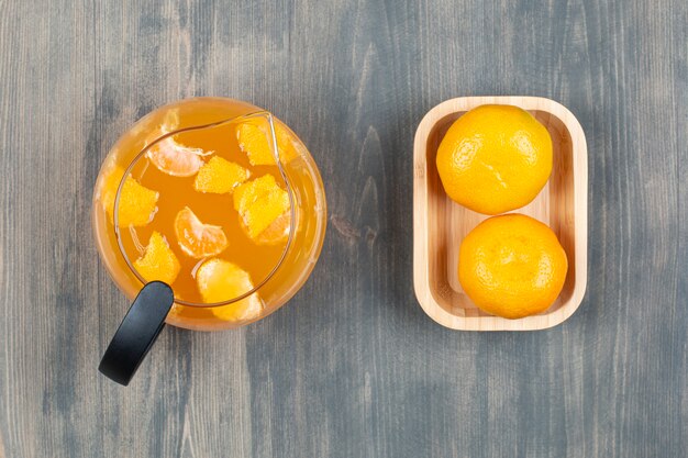 Deux mandarines fraîches avec un pot en verre de jus