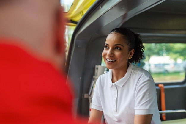 Photo gratuite deux médecins près de l'ambulance des ambulanciers paramédicaux près de l'ambulance souriant