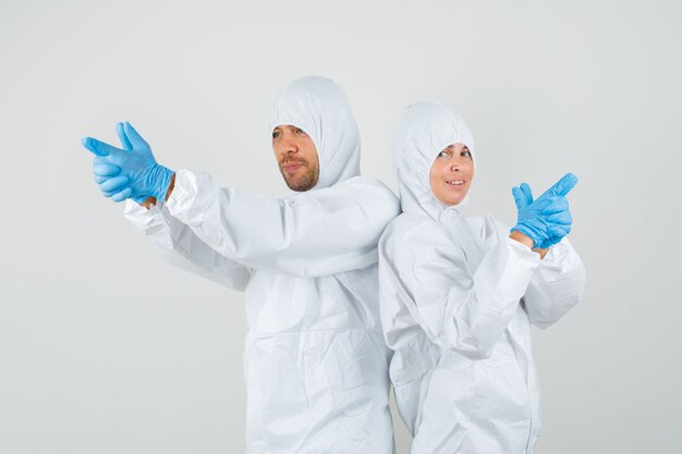 Deux médecins en tenue de protection, gants faisant le geste des armes à feu