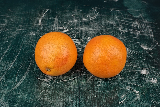 Deux oranges mûres sur une surface en marbre.