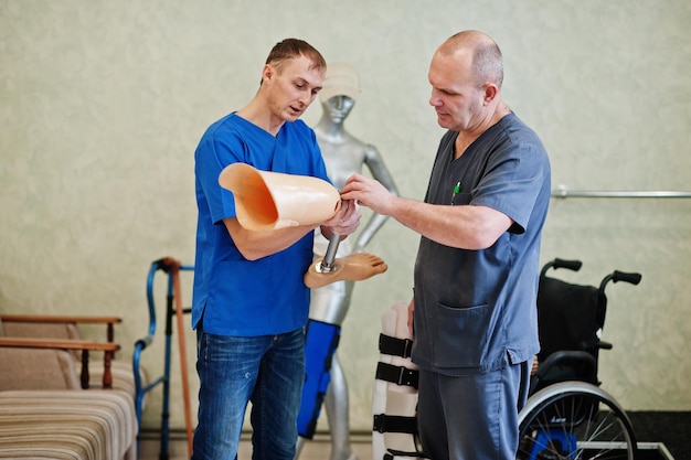 Photo gratuite deux ouvriers prothésistes avec jambe prothétique travaillant en laboratoire