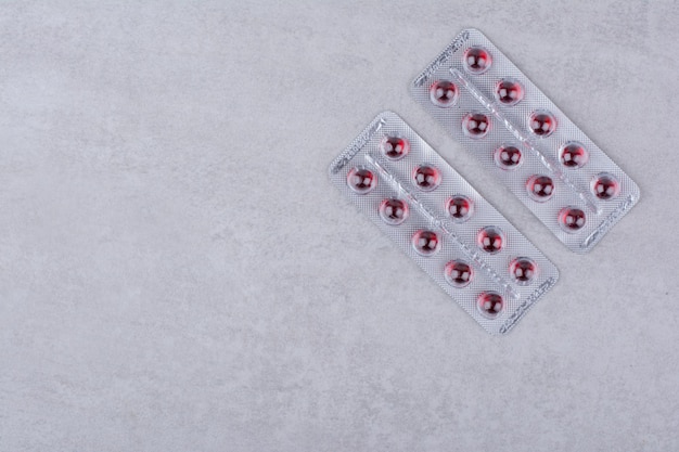 Deux paquets de médicaments rouges sur une surface en marbre. photo de haute qualité