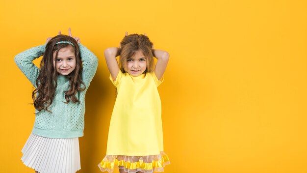 Deux petites filles faisant des cornes avec les doigts