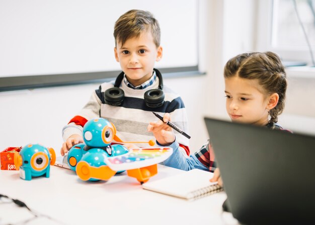 Deux petits enfants jouant avec des jouets numériques dans la classe