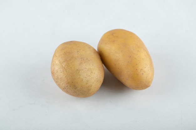 Photo gratuite deux pommes de terre fraîches sur fond blanc.