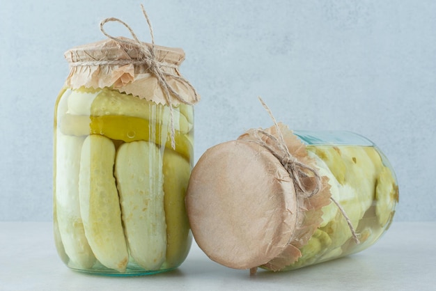 Deux pots de légumes marinés sur bleu