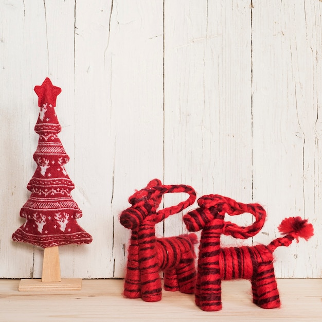 Photo gratuite deux rennes rouges et arbre pour noël