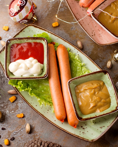 Photo gratuite deux saucisses sur la table avec du ketchup et de la moutarde